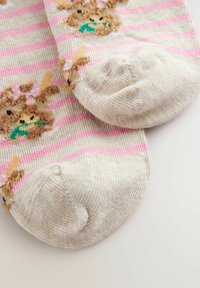 Beige Socken mit pinken Streifen und strukturierten Hasenmotiven, aus einem weichen, gemütlichen Material und mit verstärkter Zehenpartie für Langlebigkeit.