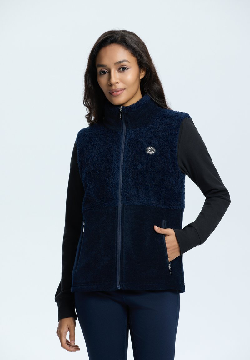 Marineblauer Fleece-Westen mit hohem Kragen, Reißverschluss vorne, zwei Seitentaschen und einem Logo auf der Brust; strukturierter, weicher Stoff.