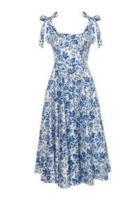 Niebieska i biała sukienka w kwiaty z kwadratowym dekoltem, wiązanymi ramiączkami i zwiewną spódnicą. Materiał zdobiony szczegółowym wzorem kwiatowym na jasnym tle.