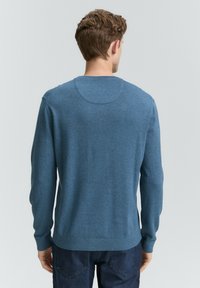 Männerblauer Pullover aus strukturiertem Stoff. Mit Rundhalsausschnitt, langen Ärmeln und gerippten Bündchen sowie Saum. Minimalistisches Design.