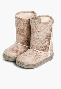 Stivaletti alla caviglia in suede color tan con una morbida fodera color crema, esterno testurizzato, dettagli intrecciati e suola piatta in gomma. Il risvolto è ripiegato verso il basso.