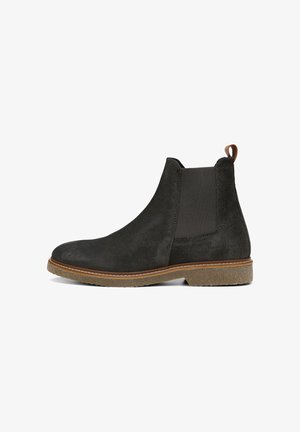 Black suede Chelsea boot with elastic side panels, a brown leather pull tab, and a textured rubber sole. Stitched detailing around the sole.