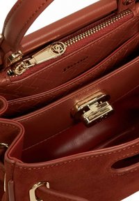Brown leather handbag with suede accents, gold-toned hardware, zippered compartment, quilted interior, and magnetic snap closure.