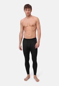 Schwarze thermische Leggings mit einem schlanken Design und elastischem Bund. Hergestellt aus weichem, dehnbarem Stoff für Komfort und Wärme.