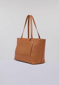 Borsa a tote in pelle marrone con due manici lunghi, una tasca frontale e una superficie liscia. Presenta un logo discreto sul davanti.