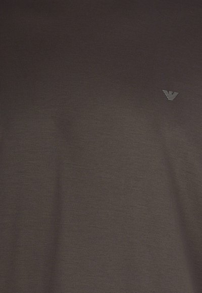 Donkerbruine t-shirt gemaakt van zachte stof, met een subtiele, kleine logo in een lichtere tint aan de bovenste linkerkant.