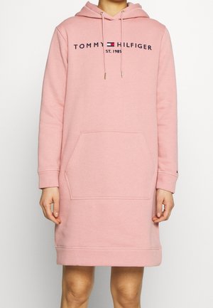 Robe sweat à capuche rose pâle avec poche avant, manches longues, cordons de serrage et logo "Tommy Hilfiger Est. 1985" sur la poitrine.
