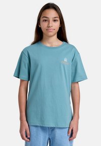 Camiseta de algodón de manga corta en color turquesa con cuello redondo. Presenta un pequeño logo blanco y naranja "Element" en el pecho.