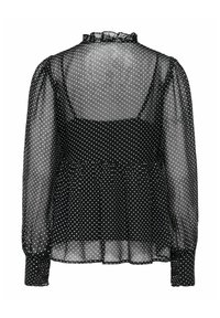 Blouse noire transparente à pois blancs, manches longues bouffantes, col à volants, et un caraco noir opaque en dessous, vue de dos.