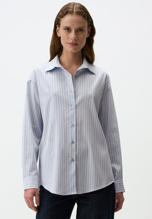 Light blue striped long-sleeve shirt with button closure, collar, and relaxed fit; made from smooth fabric with a slight sheen.