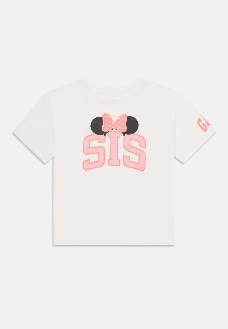 Λευκό βαμβακερό μπλουζάκι με ροζ κείμενο "SIS", μαύρες αυτιά του Μίκυ Μάους και ροζ φιόγκο με πουά. Κοντά μανίκια, στρογγυλή λαιμόκοψη και λογότυπο στο μανίκι.