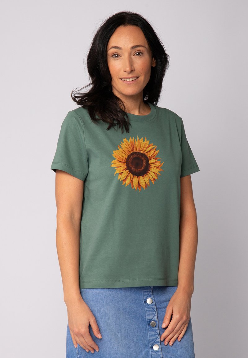 Groene katoenen t-shirt met een grote zonnebloemafbeelding in geel en bruin in het midden. Korte mouwen, ronde hals.