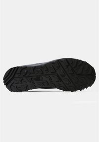 Semelle de chaussure North Face noire avec des motifs de bande de roulement profonds et robustes conçus pour l'adhérence et la durabilité en extérieur.