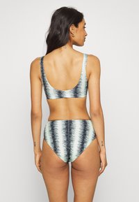 Conjunto de biquíni de duas peças em verde-claro com riscas horizontais em azul-marinho, apresentando um top com costas em formato de scoop e uma parte de baixo de cintura alta. Tecido de textura suave.