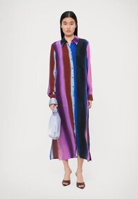 Rochie lungă, cu nasturi, având dungi verticale în nuanțe de albastru, mov și burgund. Fabricată dintr-un material neted, cu un buzunar pe piept.