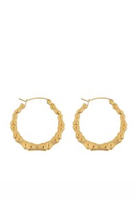 Boucles d'oreilles en or en forme de cercle avec un design texturé en bambou, présentant des segments irréguliers et un fermoir simple, créant une apparence subtile et organique.