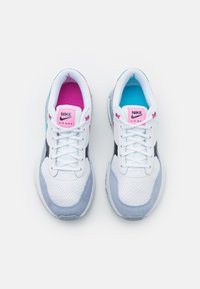 Le sneaker Nike Air Max presentano una parte superiore in rete bianca con accenti in suede grigio, foderature interne rosa e blu e pannelli laterali neri.