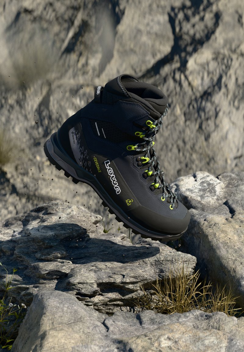 Bota de caminhadas preta com detalhes em amarelo, feita de materiais têxteis e borracha, design de cano médio, sola texturizada e atada com cordões robustos.