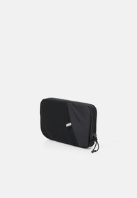Black storage pouch featuring a textured mesh panel and smooth fabric. Zipper closure with a soft pull tab for easy access.