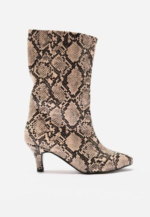 Stiefel bis zur Mitte der Wade mit spitz zulaufender Zehenpartie, Schlangenledermuster und niedrigem Kitten-Heel in Beige- und Schwarztönen vor weißem Hintergrund.