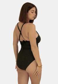 Maillot de bain noir texturé avec un motif en chevrons, doté de bretelles croisées dans le dos et d'un détail noué en dessous de la taille.