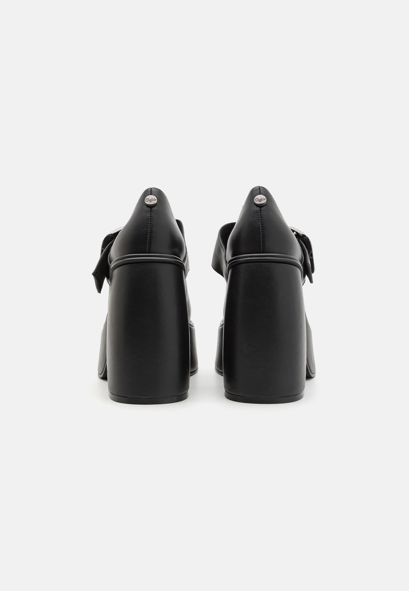 Scarpe con tacco alto in pelle nera con un evidente zeppa, texture liscia, retro arrotondato e accentuazione decorativa a forma di fiocco nella parte anteriore.