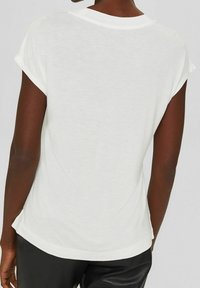 Weißes T-Shirt mit kurzen Ärmeln und Rundhalsausschnitt. Weicher Stoff und lockere Passform. Leicht abgerundeter Saum hinten, keine sichtbaren Grafiken oder Muster.