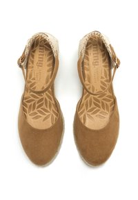 Scarpe in suede marrone con dettagli intrecciati, punta rotonda, cinturino alla caviglia e solette in pelle con un intricata trama a foglia. Suole piatte in stile espadrilles.