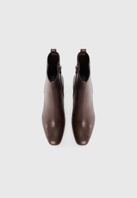 Brown leather ankle boots with a pointed toe design, featuring a side zipper and a smooth texture.