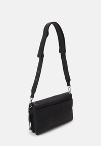 Schwarze Umhängetasche aus strukturiertem Leder. Verfügt über einen verstellbaren Riemen und metallische Hardware-Akzente. Minimalistisches Design mit klaren Linien.