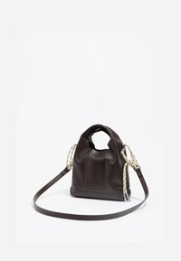Ciemnobrązowa skórzana torebka z okrągłym uchwytem, szczegółem w formie naszywki z przodu, beżowymi sznurowymi akcentami po bokach oraz długim regulowanym paskiem na białym tle.