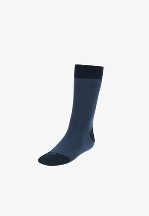 Calcetín azul oscuro hecho de tela suave. Parte superior acanalada, talón y puntera reforzados, variaciones de color tonales. Diseño simple y funcional.