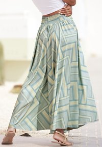 Lahka, krilnata dolžina krila v svetlo zeleni tkanini, ki se ponaša z geometrijskim vzorcem v modrih in smetanastih odtenkih. Elastičen pas za udobno prileganje.