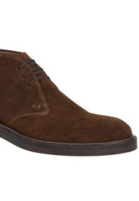 Hnědé semišové pánské společenské boty na šněrování s černou podrážkou a podrobným prošíváním podél okraje, zobrazené z bočního úhlu.