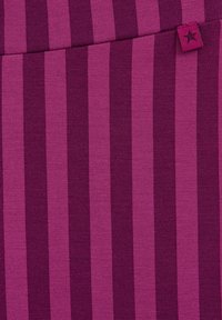 Fuksiaroosa kangas, millel on vertikaalsed triibud erinevates lillakates toones. Ainult väike silt tähtega õmbluse lähedal.