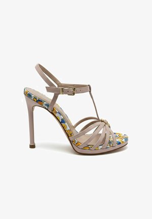 Sandale beige à talon haut avec bride à la cheville, boucle dorée, design à bride en T et motif floral coloré sur la semelle intérieure et la semelle.