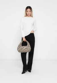Hobo bag in beige with snake print pattern, made of faux leather. Features a rounded handle and soft, textured surface.