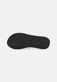 Semelle de chaussure en caoutchouc noir avec un motif floral, présentant des motifs gravés et des accents en relief pour la adhérence et la texture. Fini lisse dans l'ensemble.
