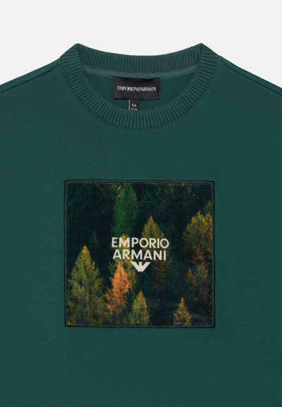 Grüner Baumwoll-Sweatshirt mit Rundhalsausschnitt, versehen mit einem quadratischen Patch, der Waldmotive und das weiße Logo "EMPORIO ARMANI" zeigt.