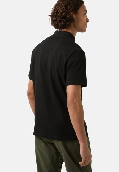 Short-sleeve, black polo shirt made of cotton with a classic collar. Features a straight hem and tailored fit.