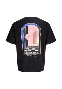 Μαύρο μπλουζάκι με μεγάλο σουρεαλιστικό σχέδιο αψιδωτού παραθύρου που δείχνει ροζ σφαίρες και δάπεδο με καρό, με ετικέτα "Beyazit St. Regis Palace Istanbul".