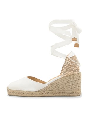 Espadrille blanche à talon compensé fermé, avec plateforme en jute tressé et liens à nouer à la cheville en tissu blanc assorti.