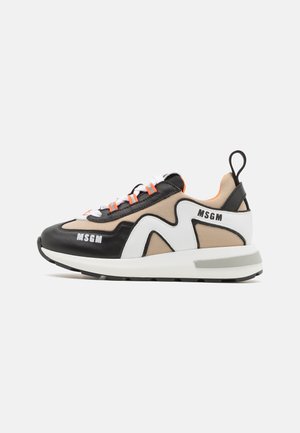 Baskets MSGM noires, blanches et beiges avec boucles de lacet orange, semelle blanche épaisse et languette noire au talon, vues de côté.