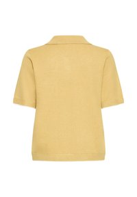 Polo en maille beige à manches courtes avec poignets, ourlet et col côtelés, vu de dos sur fond blanc.