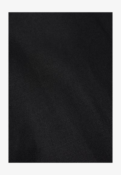 Fekete, finoman szövött mintázatú textúrált szövet közeli felvétele, finom fény-árnyék játékokkal.