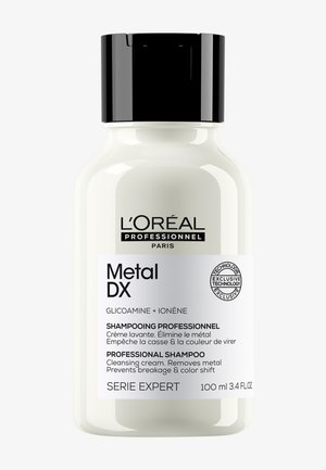 Bouteille de shampooing L'Oréal Professionnel Metal DX, 100 ml, avec capuchon noir, étiquette blanche, élimine les métaux, prévient la casse et le changement de couleur.
