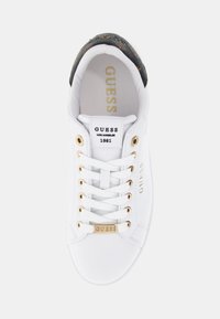 Białe sneakersy z gładką skórzaną cholewką, złotymi akcentami, detalem logo po bokach oraz wzorzystym tabem na pięcie. Klasyczny sznurowany design.
