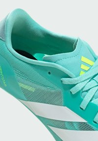 Light blue athletic shoe with mesh upper, white stripes, and yellow accents. Features a supportive collar and laces for secure fit.