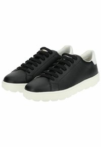 Sneakers in pelle nera con suole in gomma bianca, punta arrotondata, lacci frontali e dettaglio del tallone bianco a contrasto. Texture liscia e design minimal.