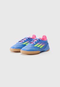 Niebieskie buty sportowe z różowymi akcentami i neonowymi zielonymi paskami. Wykonane z teksturowanego materiału z gumową podeszwą, z zapięciem na sznurówki.